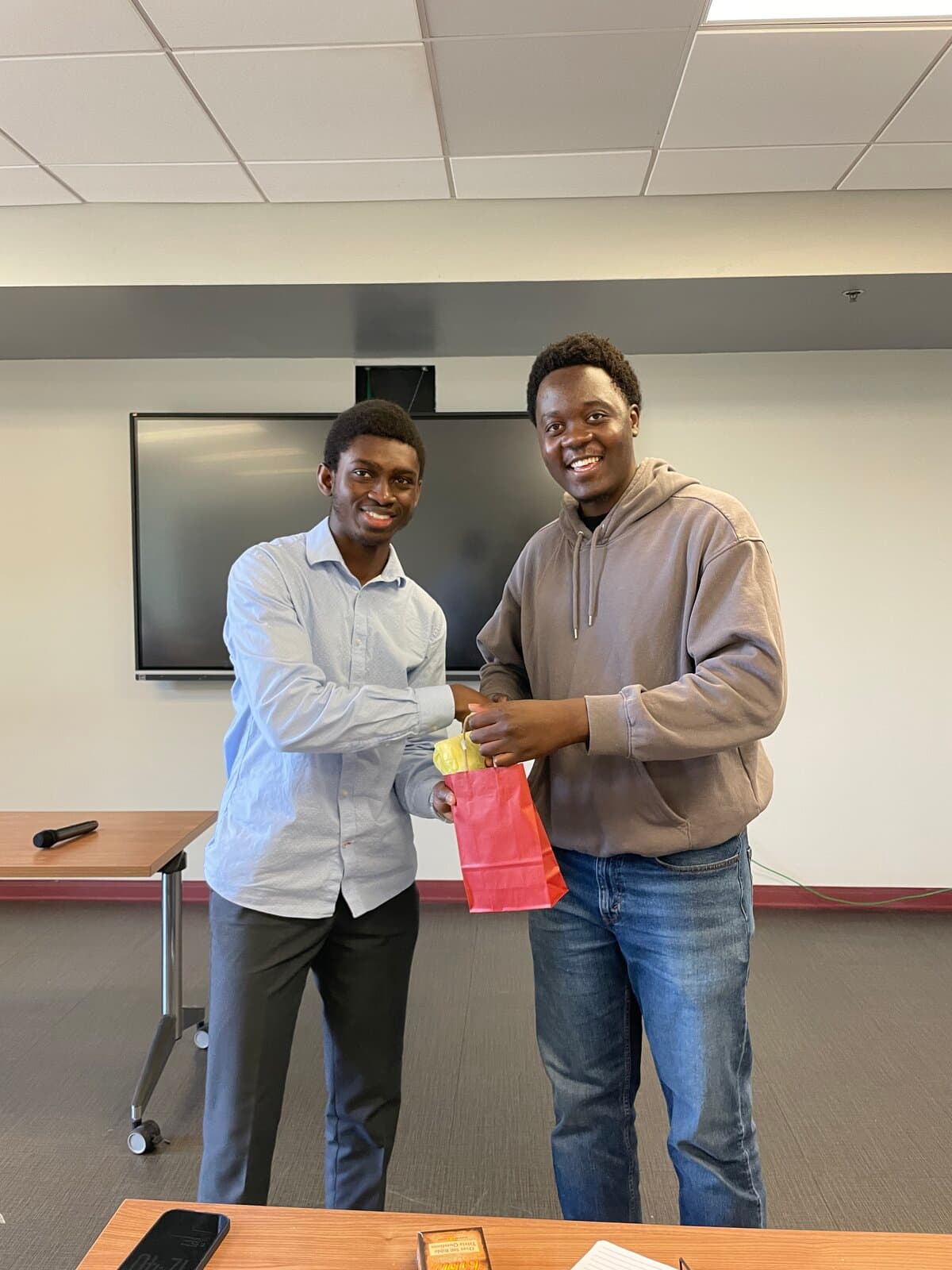 Members sharing a gift and handshake at fellowship meeting