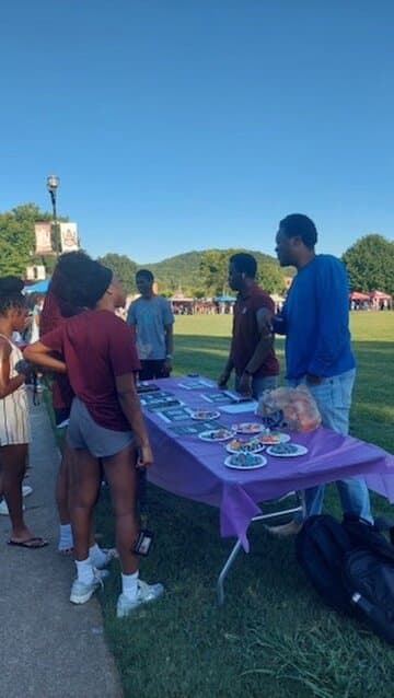 CCF members welcoming students at the purple outreach table